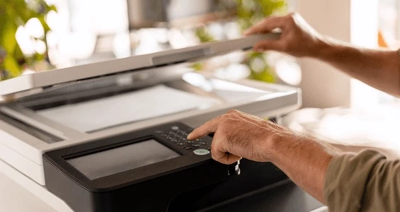 Proces skanowania dokumentów papierowych w celu przejścia na cyfrowy obieg akt w firmie.